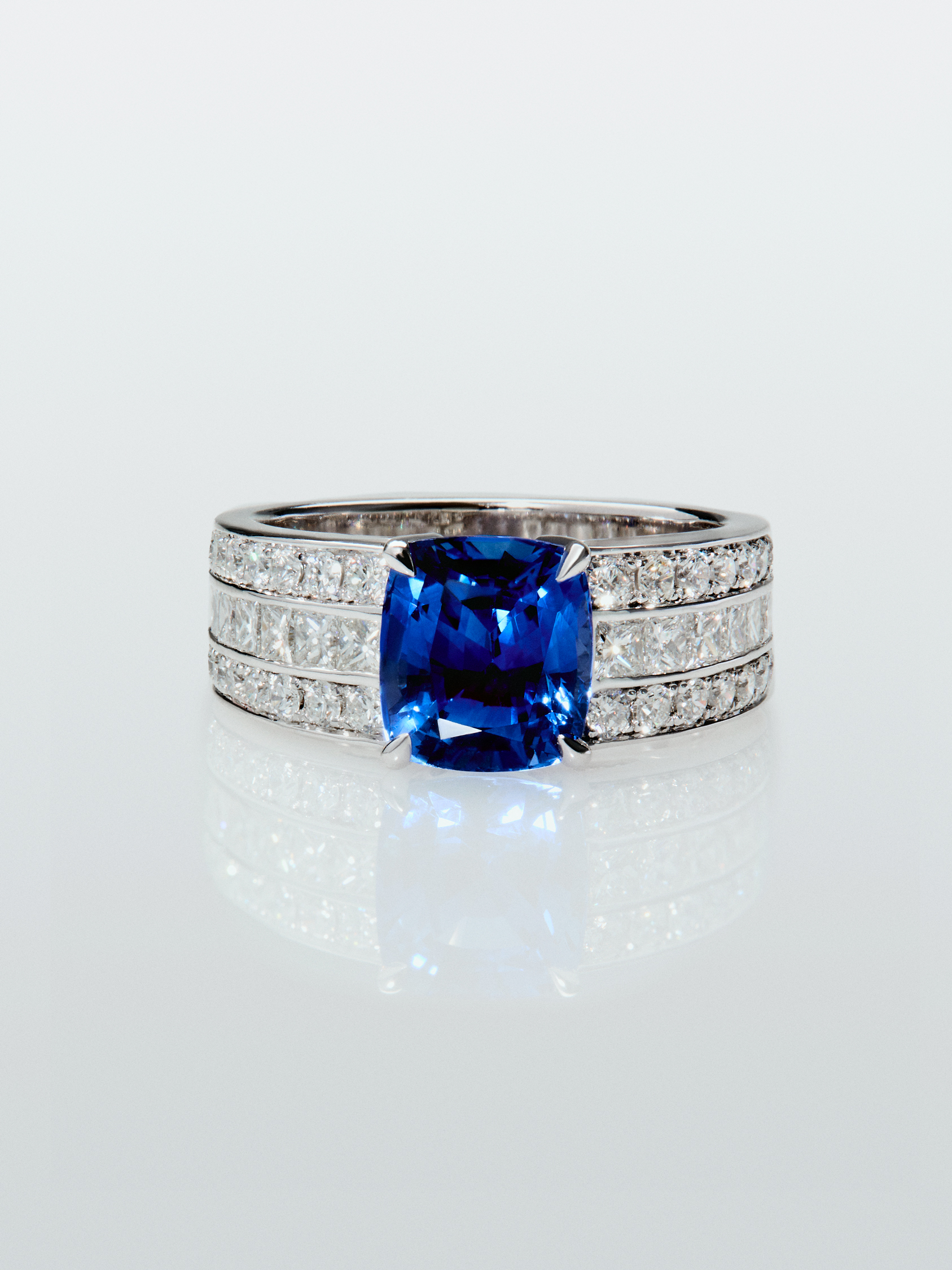 18K white gold ring with cushion-cut royal blue sapphire of 3.217 cts, 50 brilliant-cut diamonds with a total of 1.05 cts and 8 princess-cut diamonds with a total of 0.48 cts