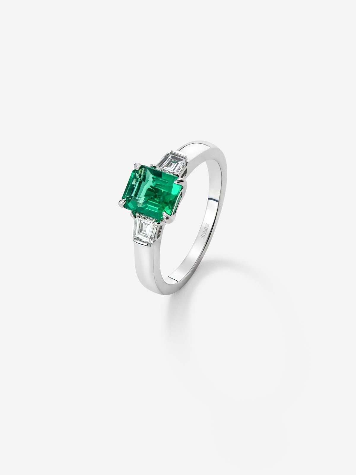 Anillo tresillo de oro blanco de 18K con esmeralda verde vivid en talla esmeralda de 1,64 cts y 2 diamantes blancos en talla fantasía con un total de 0,4 cts